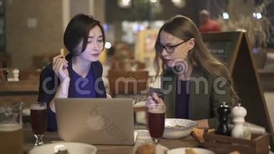 两名年轻女子讨论工作计划，晚上在咖啡馆吃饭